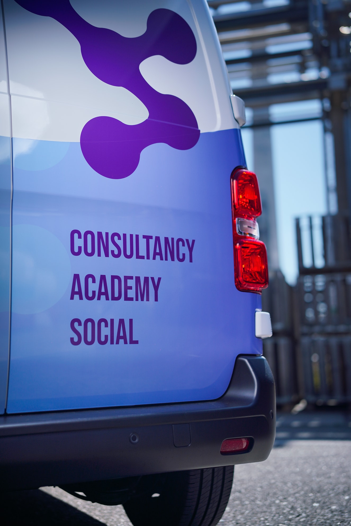 Een werkbus met het You & SHE logo, en de teksten "Consultancy", "Academy", en "Social".